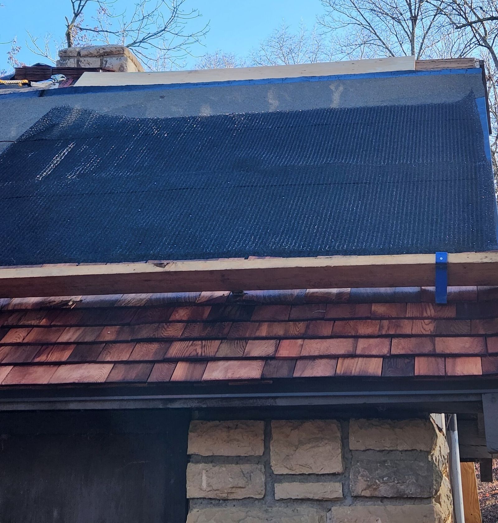 Inspecting a repaired section of shingle roof