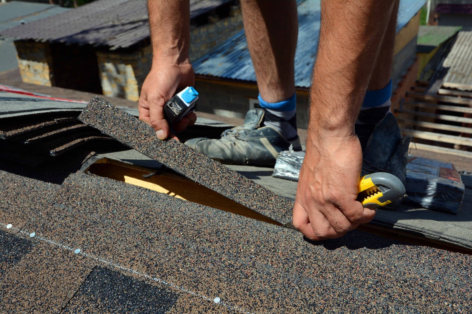 Roofer laying architectural shingles on a residential roof